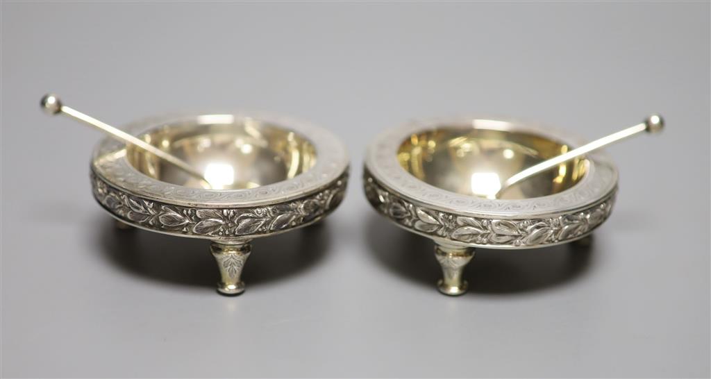 A pair of Victorian silver circular salts and matching spoons, on tripod stump feet, The Barnards, London, 1874,
